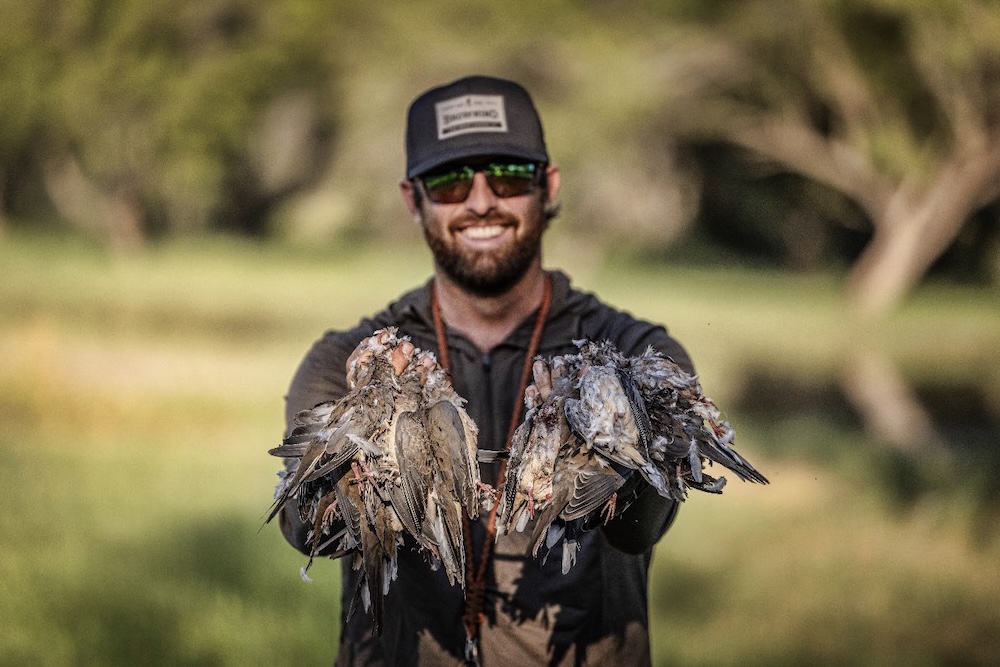 Hunter holding several birds.
