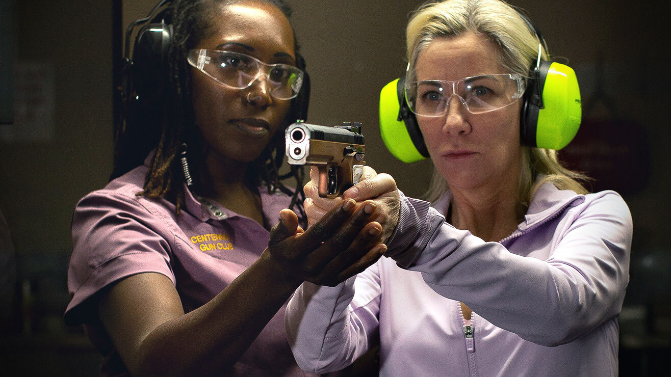 Instructor showing shooter how to aim a handgun